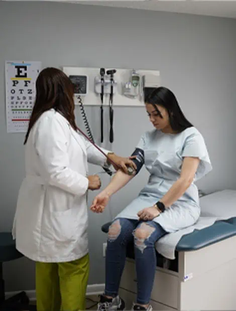 Clinician taking a patient's blood pressure in an exam room